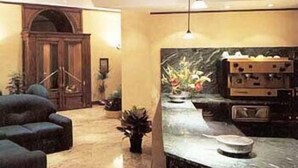 A modern kitchen with a marble countertop, a built-in oven, and a pendant light. - Hotel Valentino (Orvieto)