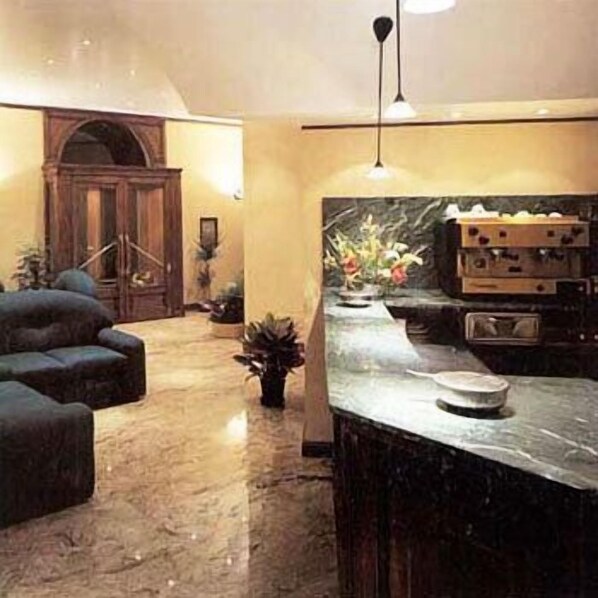 A modern kitchen with a marble countertop, a built-in oven, and a pendant light. - Hotel Valentino (Orvieto)