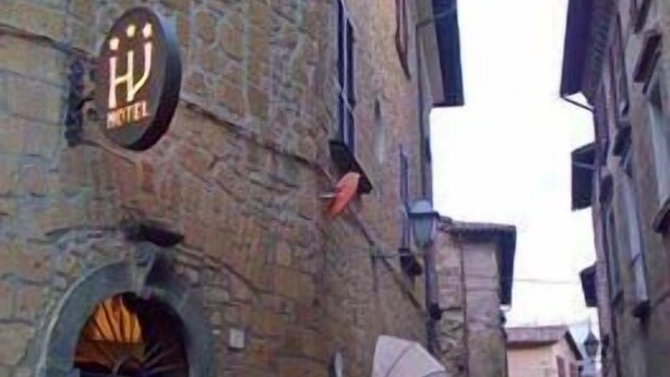 A narrow stone street with a hotel sign and an archway entrance. - Hotel Valentino (Orvieto)