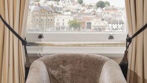 A chair by a window with a view of buildings. - The Royal Hotel (Bideford)