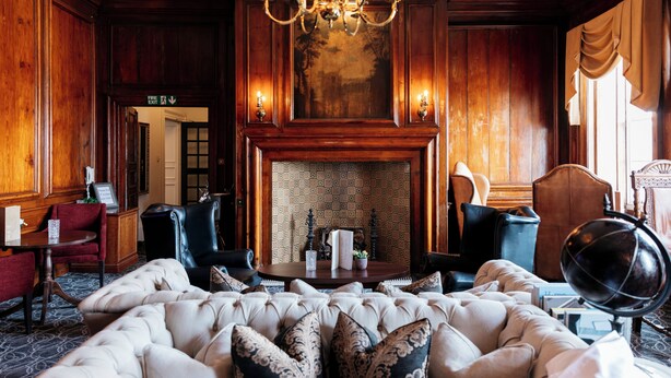 A luxurious room with a fireplace, plush seating, and a chandelier. - The Royal Hotel (Bideford)
