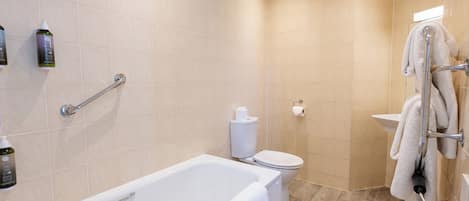 Een moderne badkamer met een badkuip, toilet en wastafel.