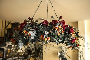 A chandelier with red roses and berries. - Albergo Filippeschi (Orvieto)