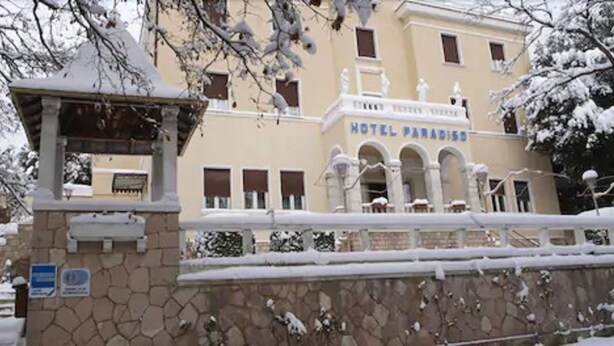 A hotel with a classical facade, multiple arches, and a snow-covered entrance. - Hotel Paradiso (Spoleto)