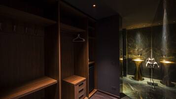 A modern bathroom with a marble floor, wooden vanity, and two illuminated sinks.