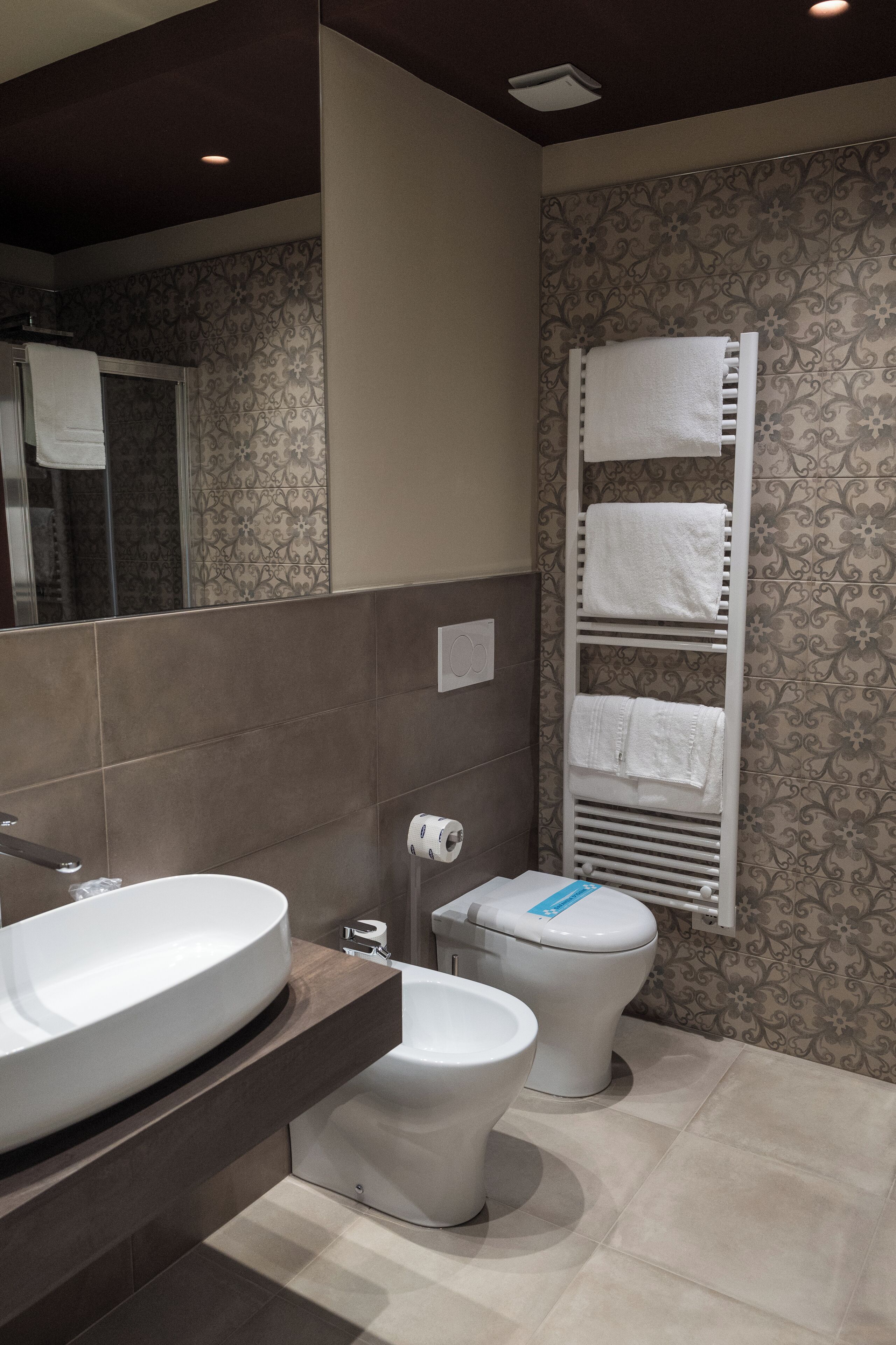 Une salle de bain moderne avec un grand lavabo, des toilettes et un porte-serviettes.