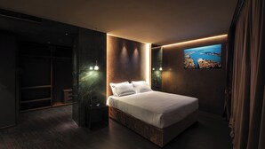 Un dormitorio moderno con una cama grande, estanterías empotradas, un televisor en la pared y vistas a la ciudad.