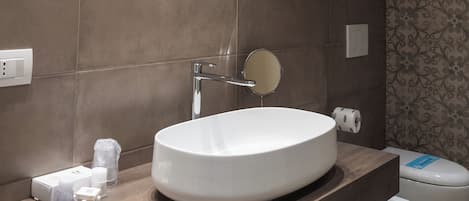 A modern bathroom with a large round sink, a mirror, and a toilet.