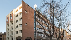 A multi-story hotel with a brick facade, a circular entrance, and a sign for 'HOTEL TOURING'.
