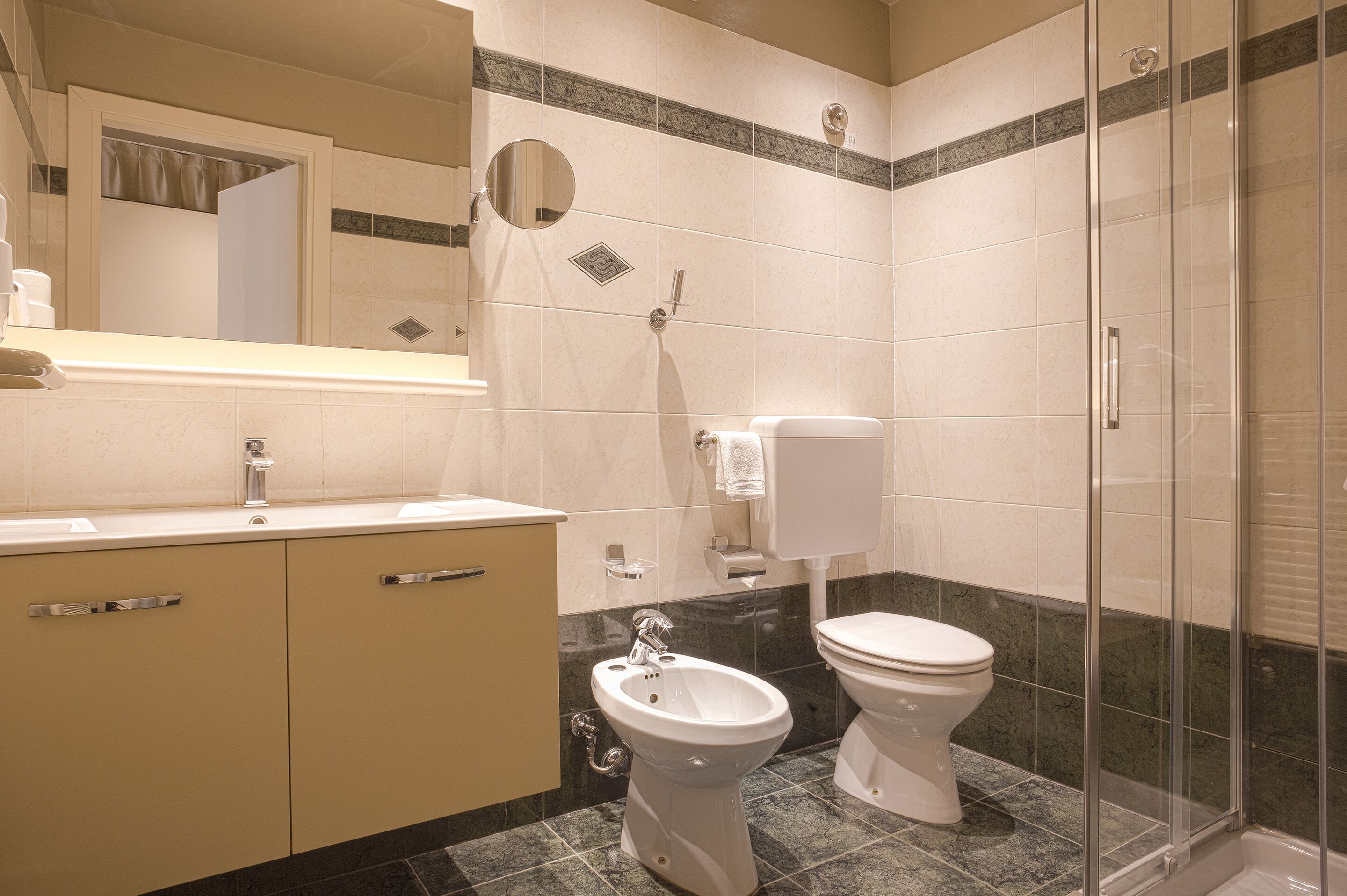 A bathroom with a toilet, bidet, and shower area.