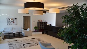 A modern living room with a sofa set, a coffee table, and a large plant. - Hotel Sagittario (Padova)