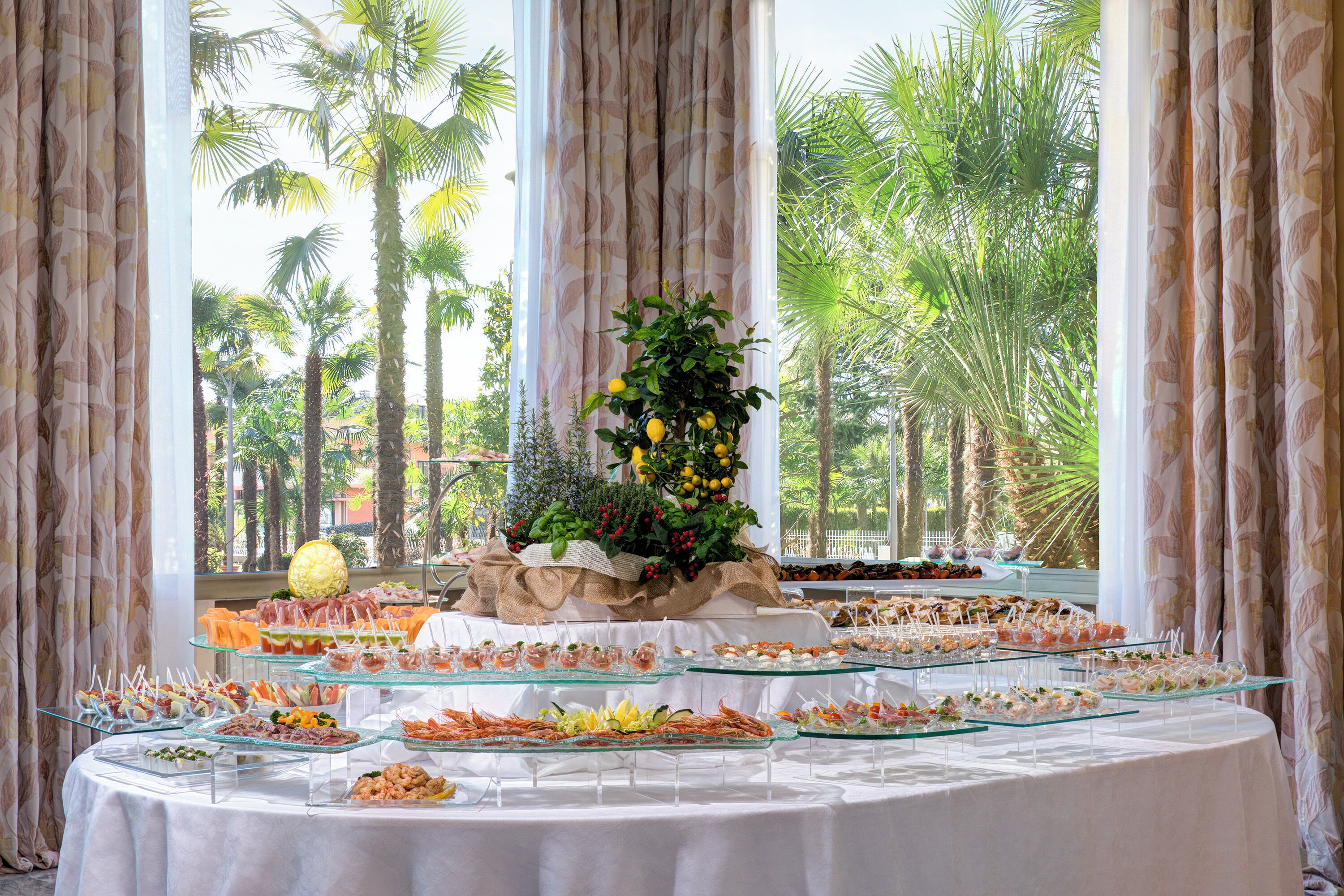 Una mesa de bufé con diversos alimentos y una pieza decorativa central.