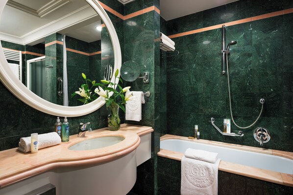 A bathroom with a sink, mirror, and bathtub. - HOTEL TERME METROPOLE – ORIENTAL SPA & RESORT (Abano Terme)