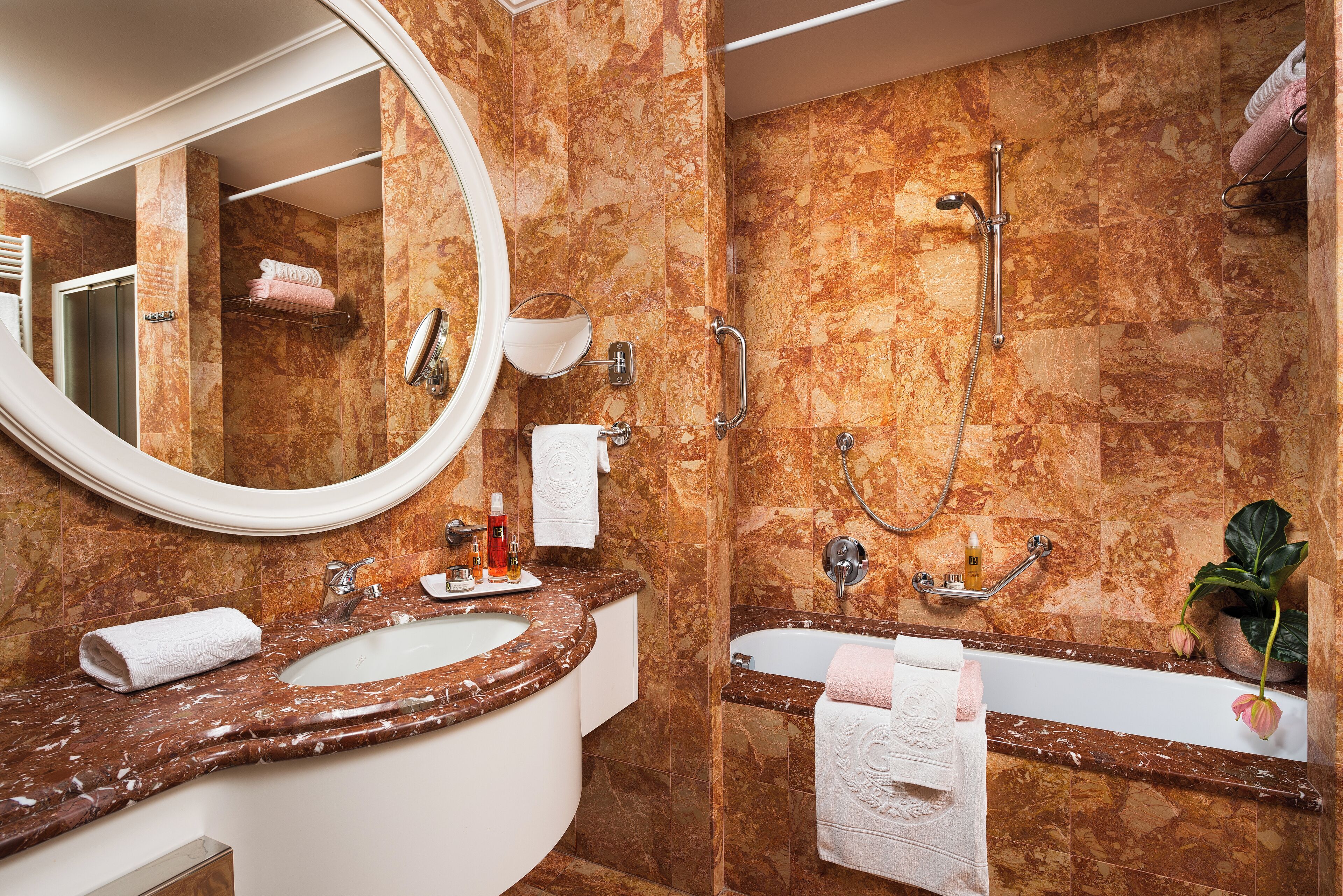 A bathroom with a marble sink, a bathtub, and a shower.