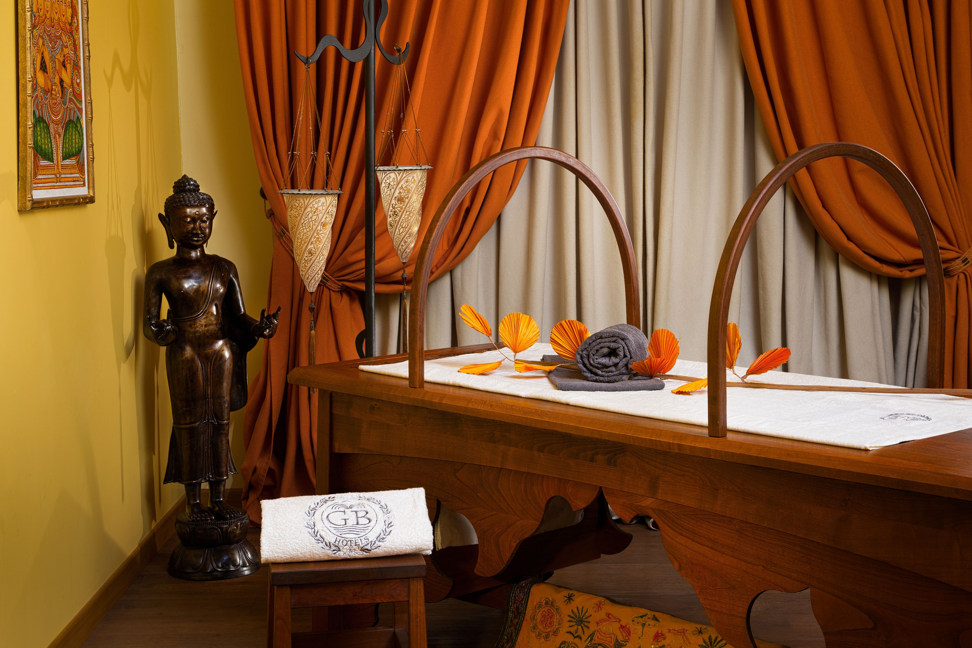 A wooden desk with a Buddha statue, a lamp, and decorative items.