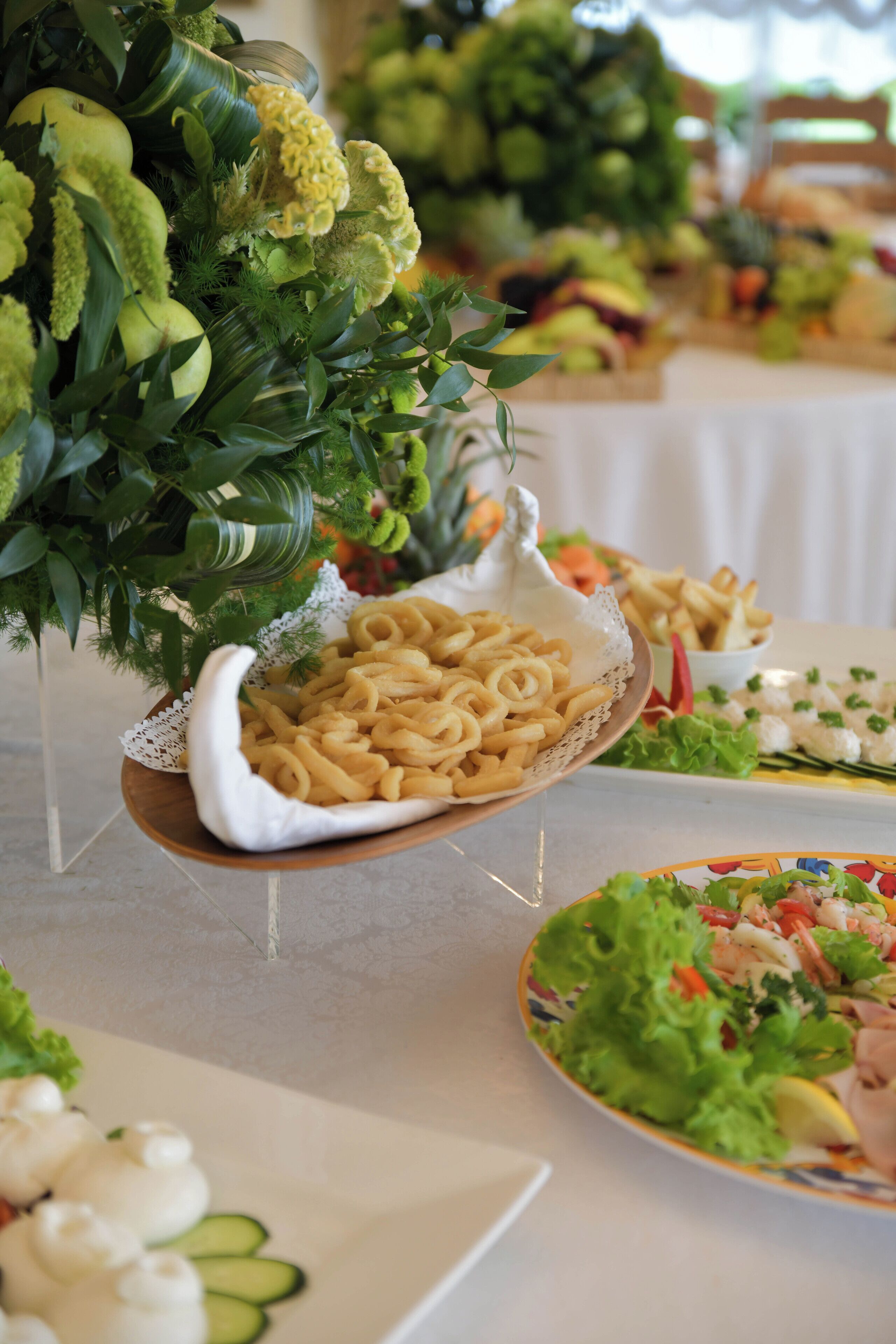A buffet table with various dishes including pasta, salads, and seafood.
