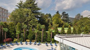 A swimming pool with lounge chairs and a building in the background. -  HOTEL TERME DUE TORRI - Adults Hideaway & SPA (Abano Terme)