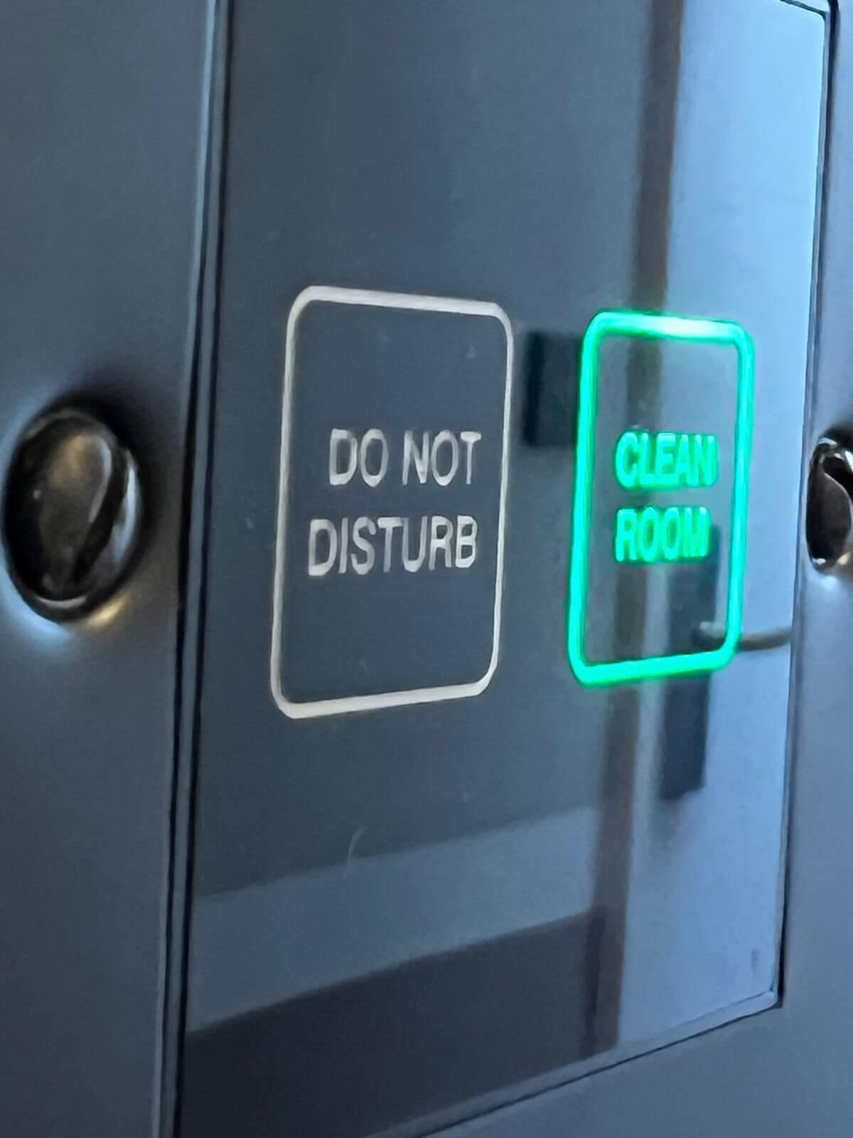 Een bedieningspaneel met twee knoppen: één met de tekst 'DO NOT DISTURB' en de ander met 'CLEAN ROOM'.