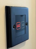 A wall-mounted control panel with two buttons: "DO NOT DISTURB" and "CLEAN ROOM".