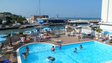 Een buitenzwembad, parasols voor strand/zwembad