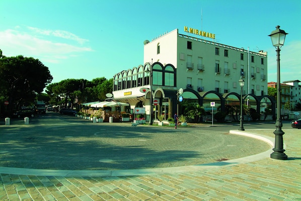 A hotel with a white facade, arched windows, and a sign reading "H. MIRAWARE". - Hotel Miramare (Cesenatico)