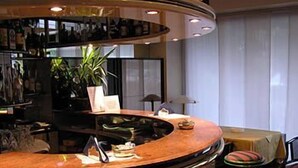 Eine Bar mit einer gebogenen Theke, Hockern und einem Blumentopf.