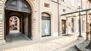 A historic building with an arched entrance, a mural, and a flag. - Best Western Premier Milano Palace Hotel (Modena)