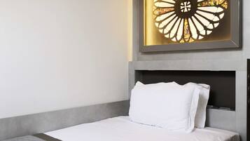 Una camera d'albergo con un letto, una testiera e un elemento decorativo a parete.