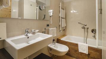 Un bagno con due lavandini, un bidet, una vasca e uno specchio.