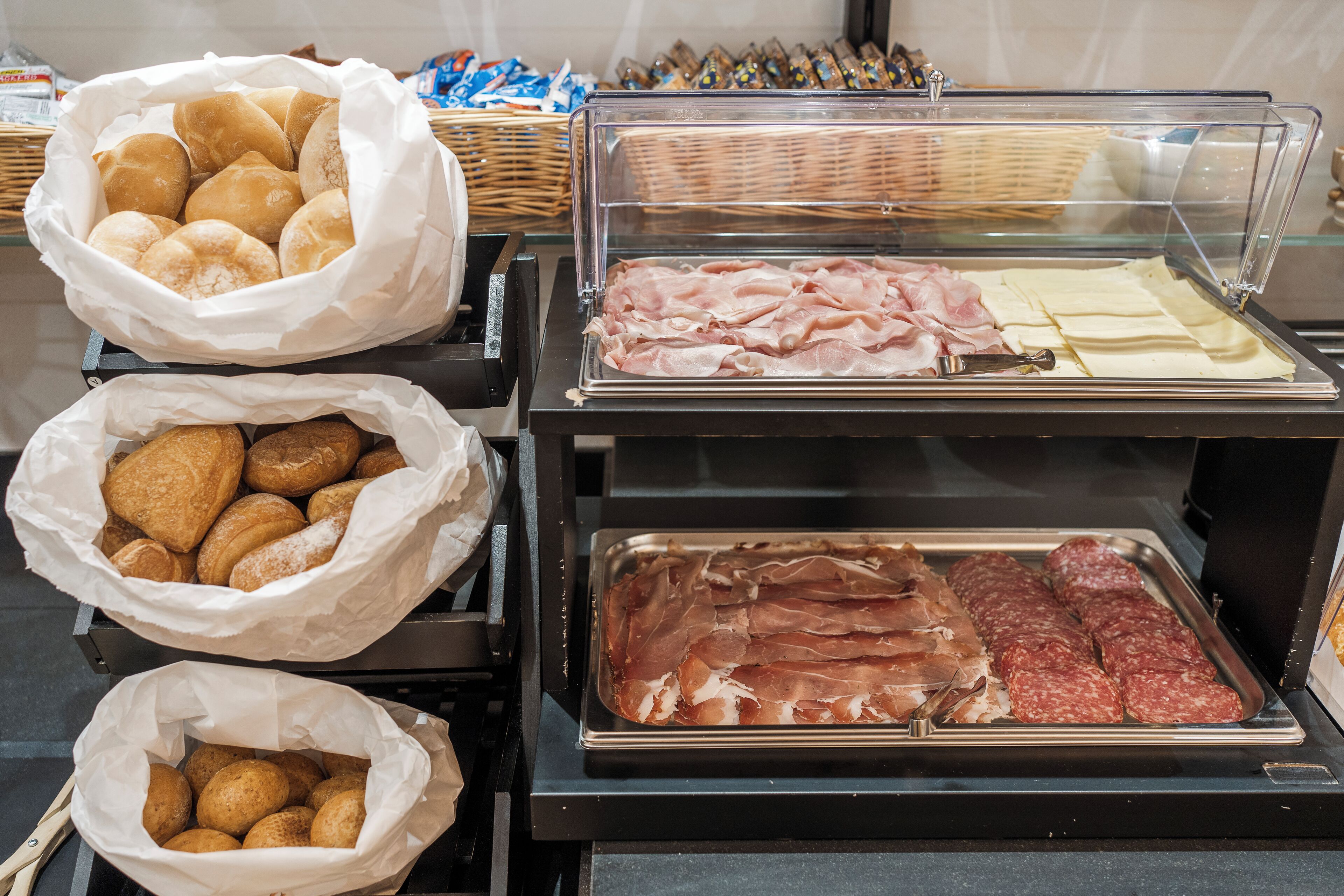 Un buffet proposant une variété de plats, notamment des pâtisseries, des viandes et des fromages.