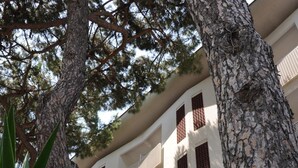 Un edificio de varios pisos con balcones, una bandera y un letrero que anuncia un evento deportivo.