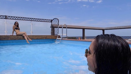 Una piscina al aire libre, sillones reclinables de piscina