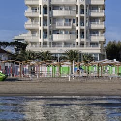 Am Strand, weißer Sandstrand, Liegestühle, Sonnenschirme