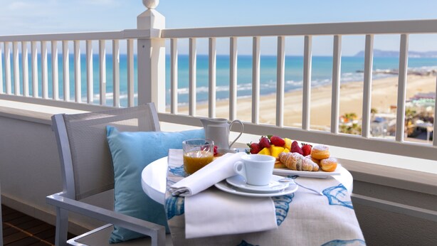 A balcony with a table set for breakfast, overlooking a beach. - Tiffany's (Riccione)