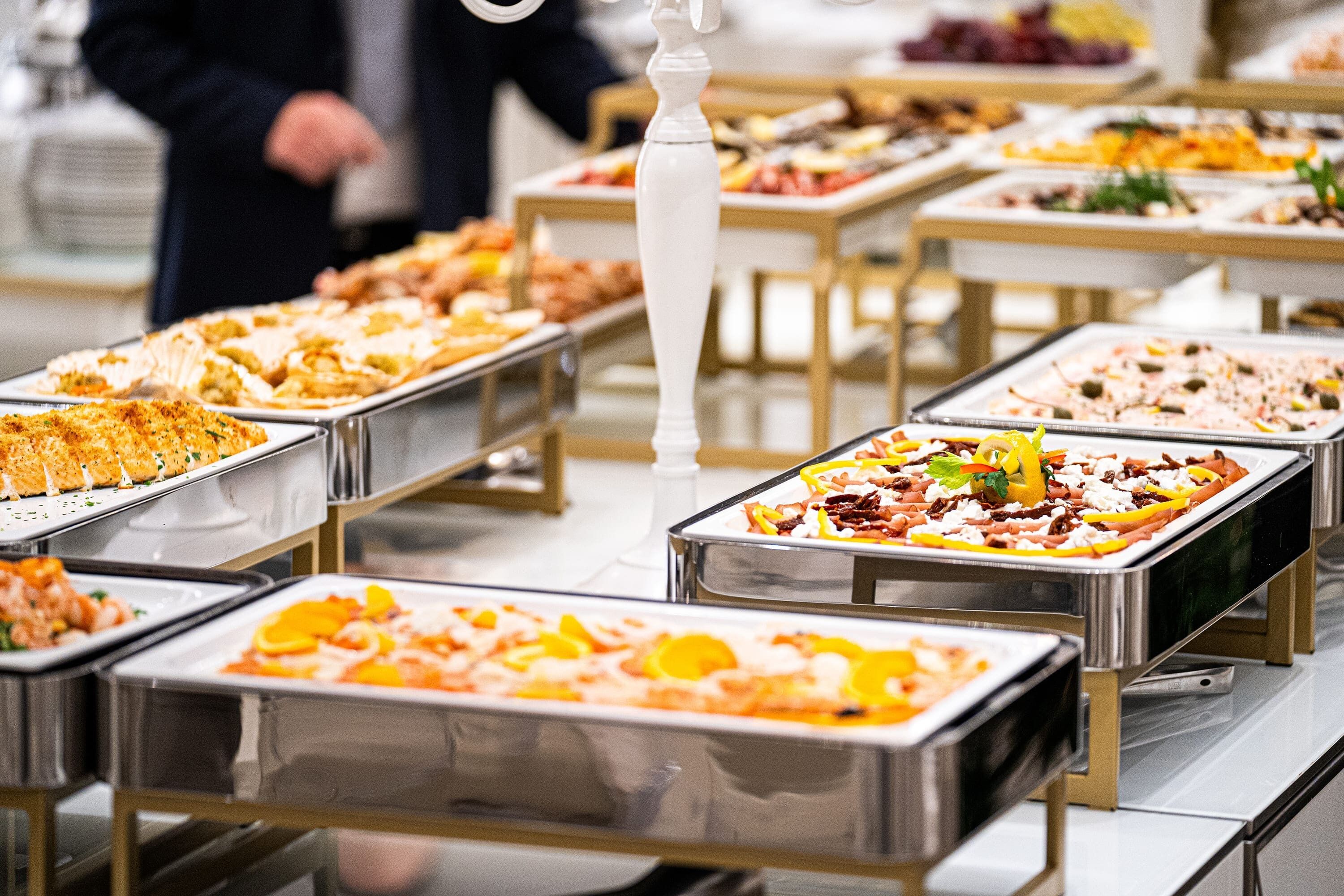 A buffet with various dishes arranged on trays.
