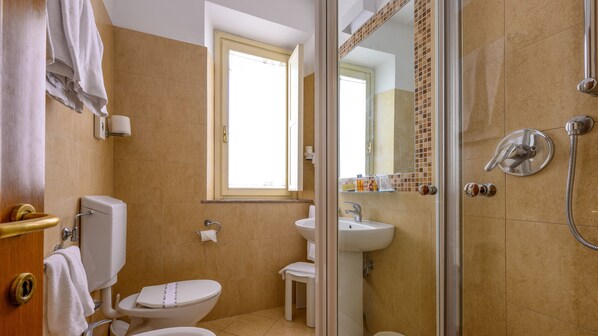 Un baño con inodoro, lavamanos y ducha.