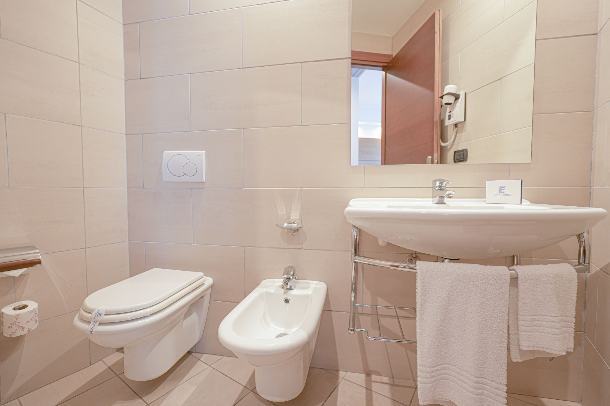 Une salle de bain moderne équipée de toilettes, d’un bidet et d’un lavabo.