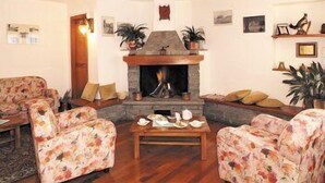 Ein gemütliches Wohnzimmer mit Kamin, Sofas mit Blumenmuster und einem Couchtisch.