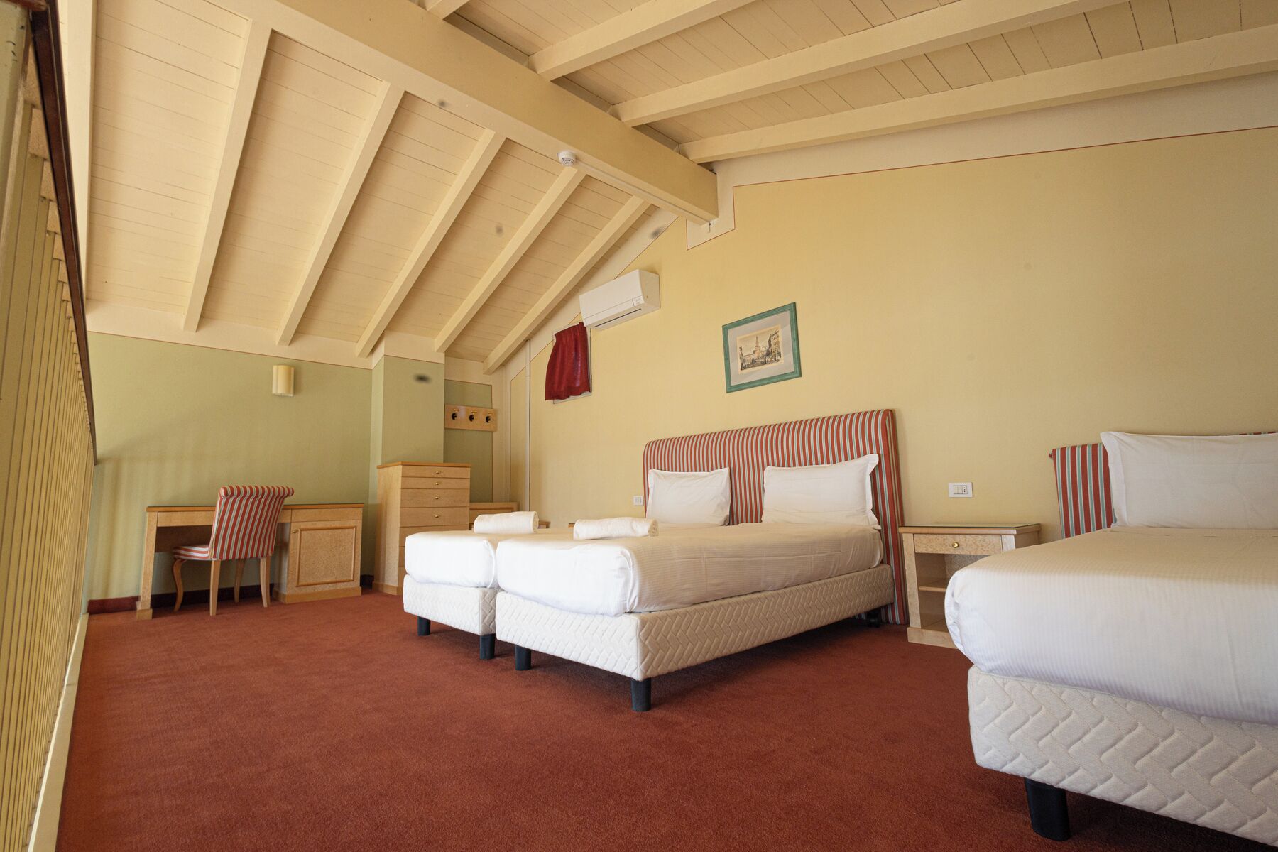 A room with two beds, a desk, and a chair.