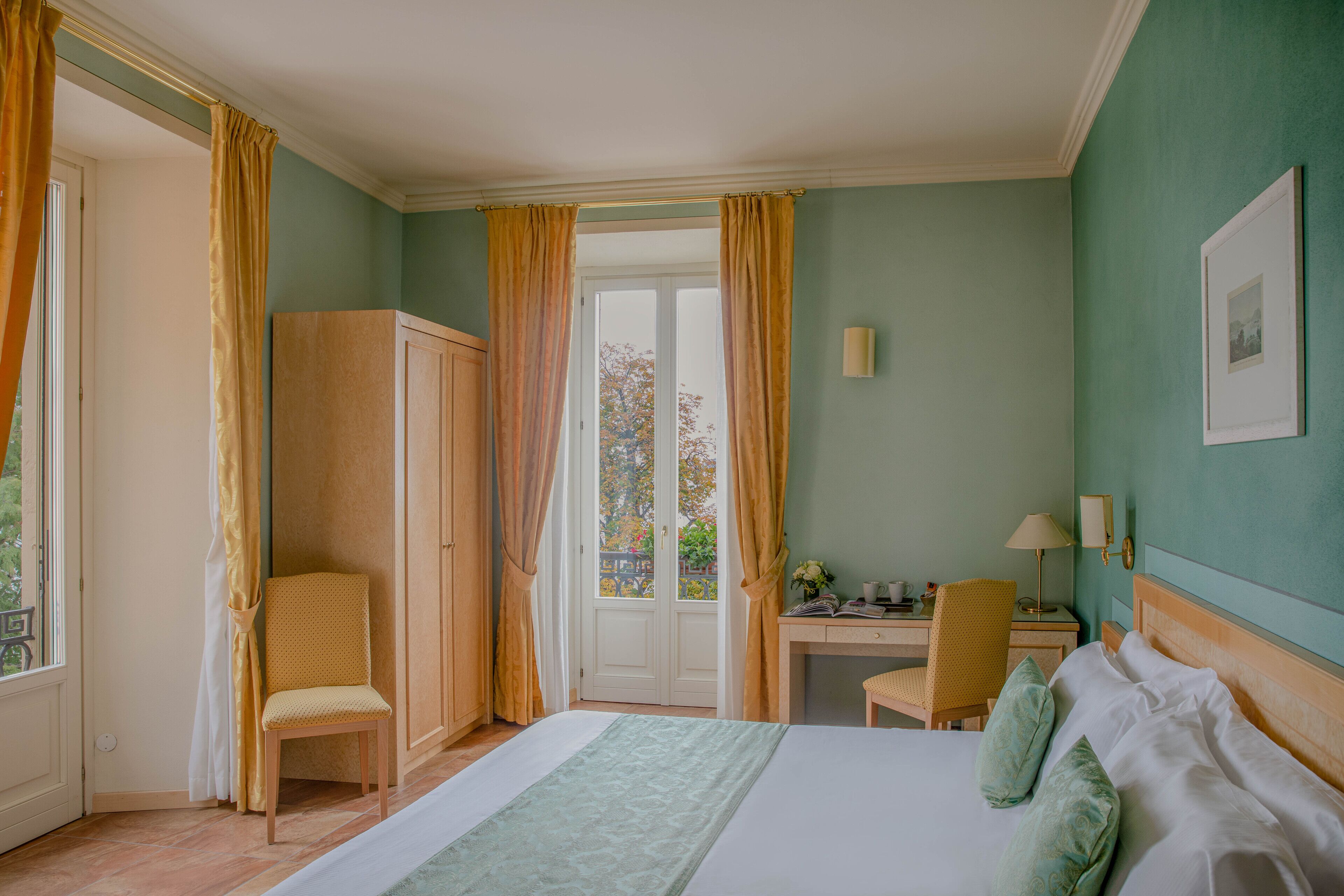 Una habitación de hotel con cama, escritorio, silla y armario.