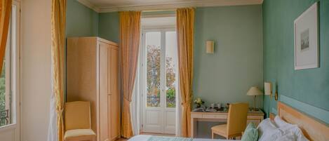 Una habitación de hotel con cama, escritorio, silla y armario.