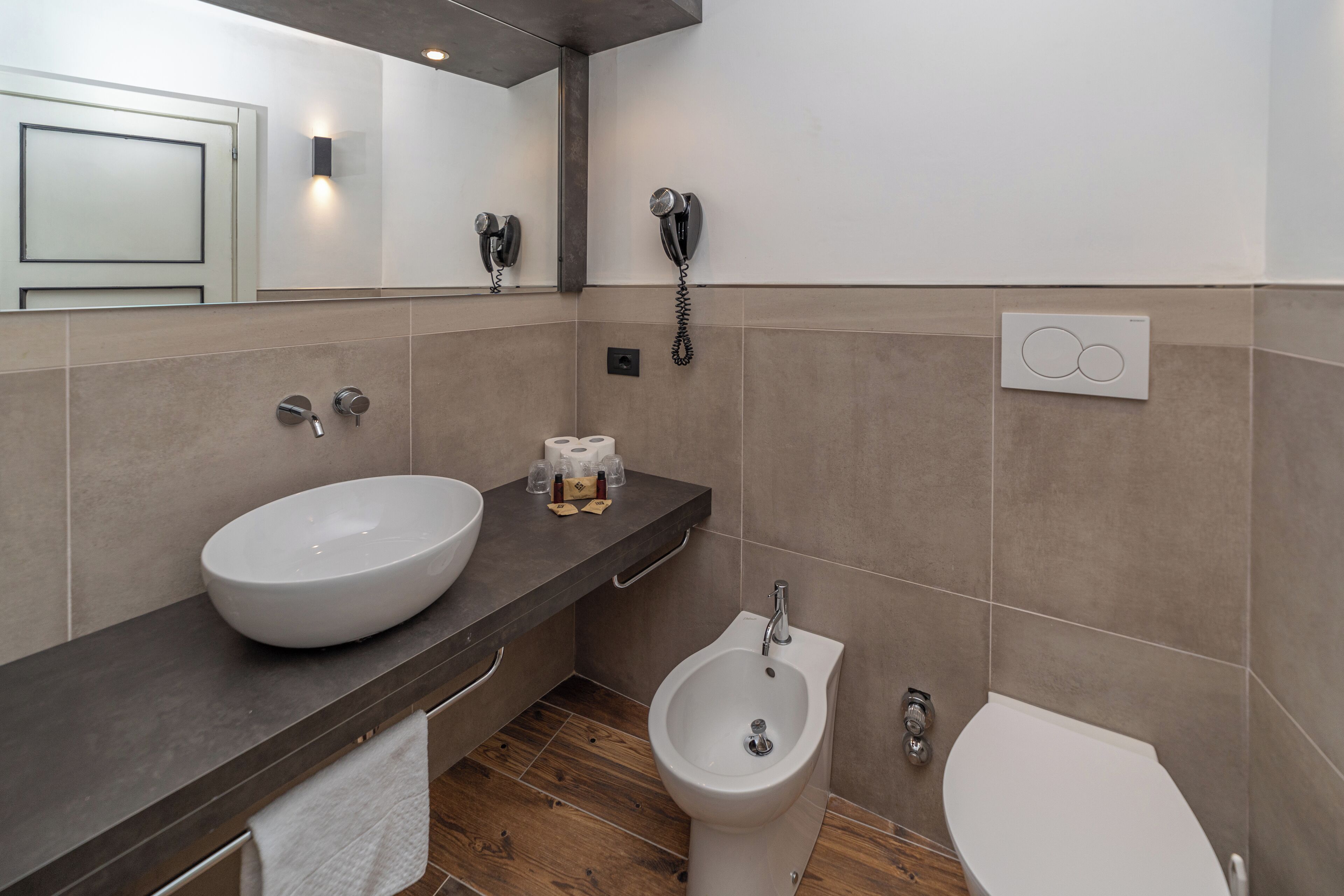 Un baño moderno con un lavamanos grande, un bidé y un inodoro.