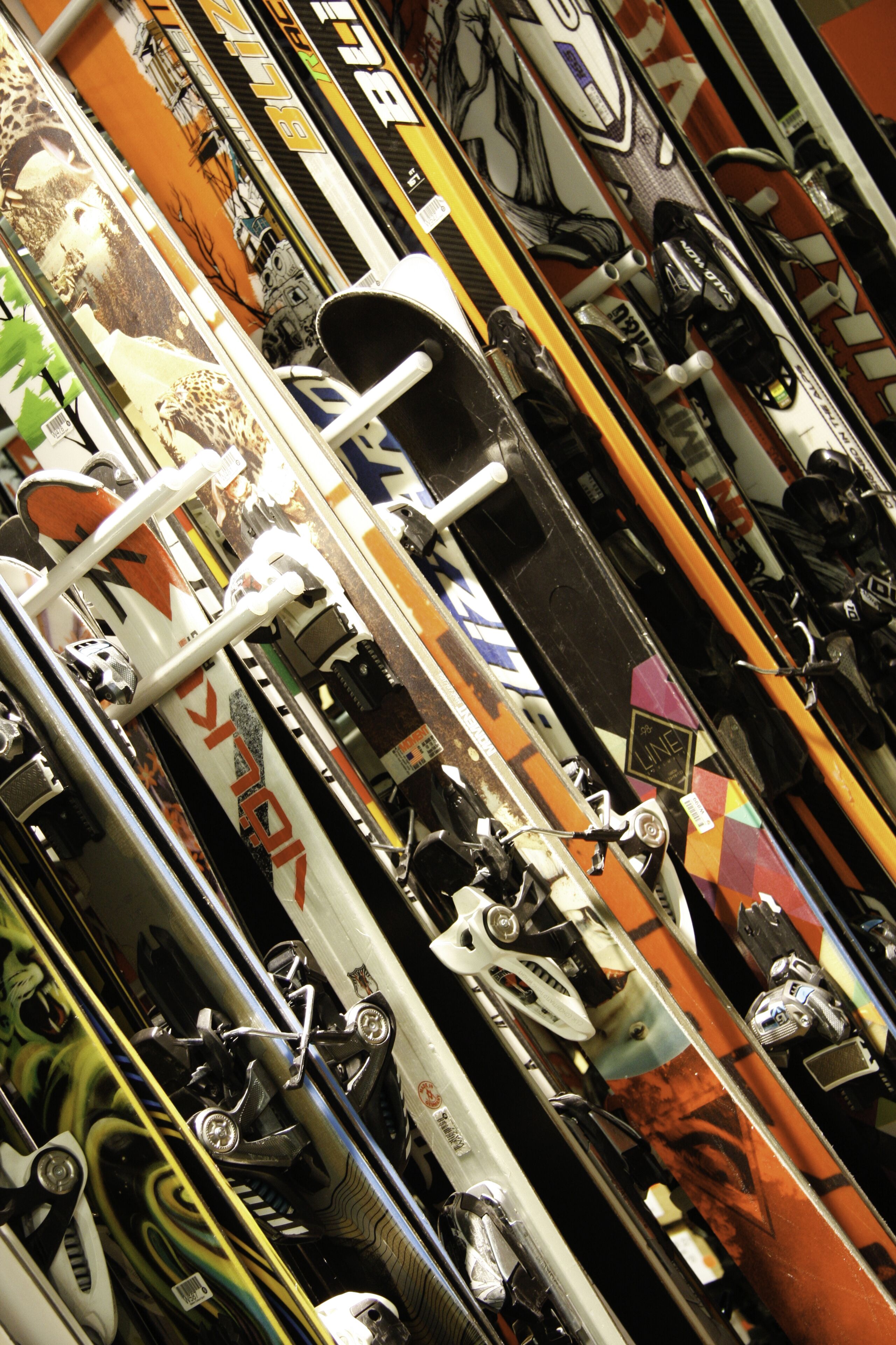 Una hilera de esquíes y tablas de snowboard en una tienda.