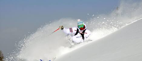 A skier in motion on a snowy slope.
