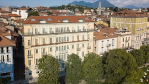 Une ville historique à l’architecture traditionnelle, avec notamment un clocher d’église imposant et une rue pavée bordée d’arbres.