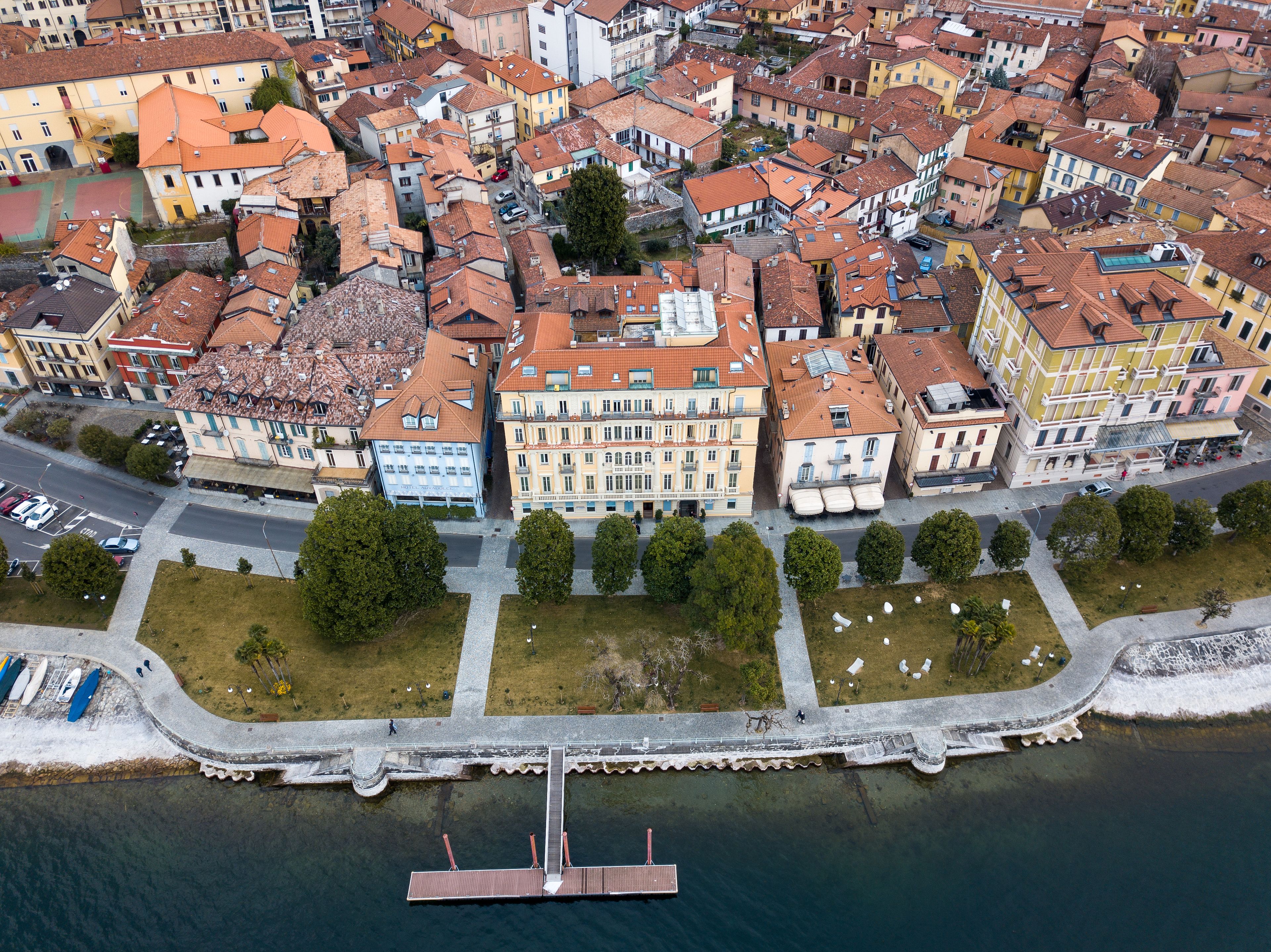 An aerial view of a densely packed urban area with historic buildings, a waterfront, and a pedestrian bridge.