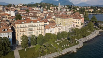 Vista aerea di una città costiera con edifici storici, una torre importante e una passeggiata sul lungomare.