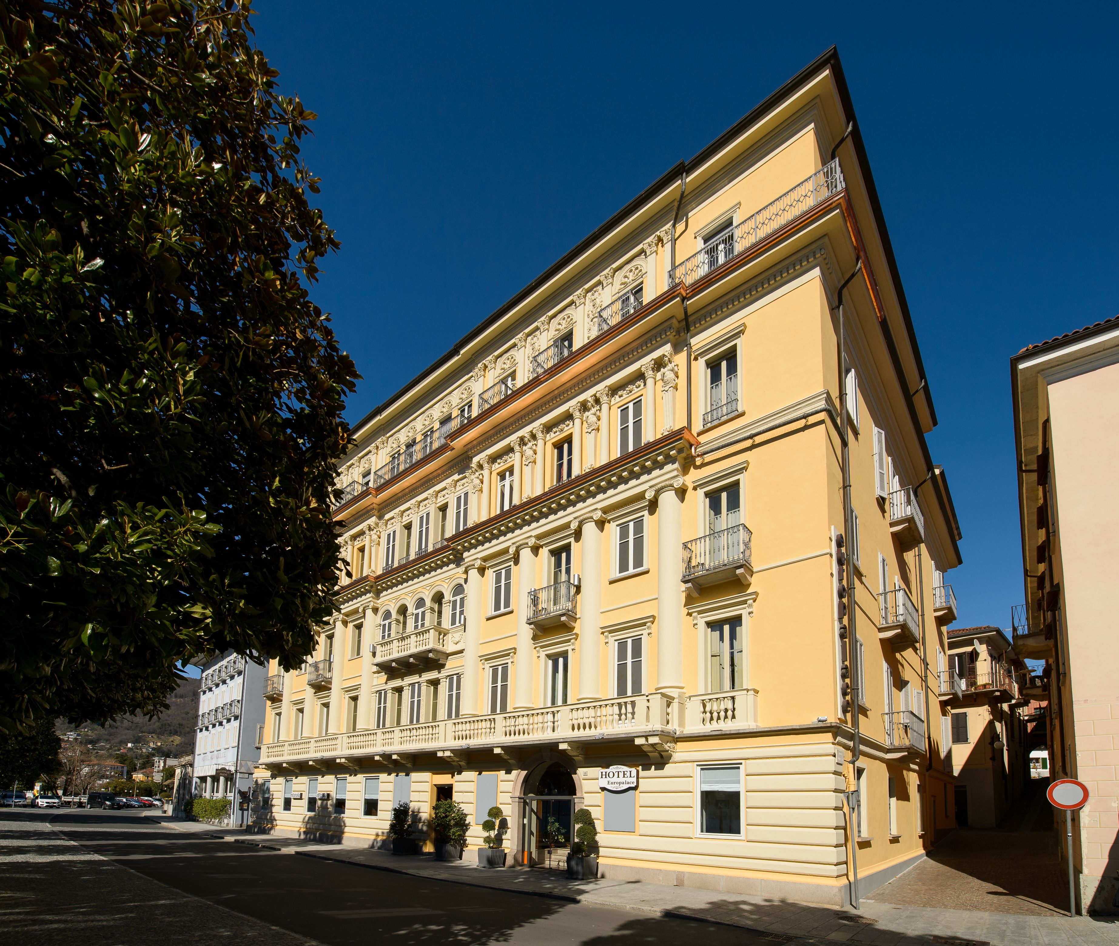 Um hotel de vários andares com estilo arquitetônico clássico, com varandas e uma entrada imponente.