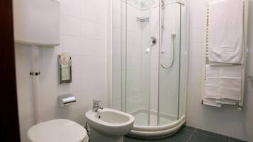 Un bagno con servizi igienici, bidet e cabina doccia in vetro.
