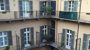 A multi-story building with balconies, each with a small potted plant. - Le Petit Hotel (Turin)